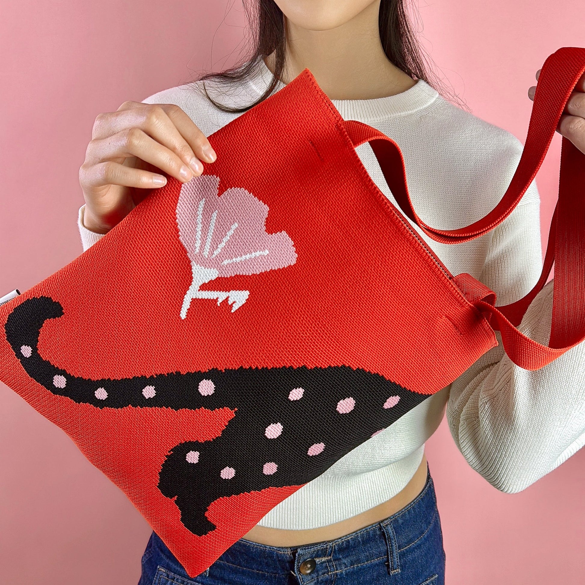 A woman carrying Beautiful polka cat tote bag knitted red pink and white black cat