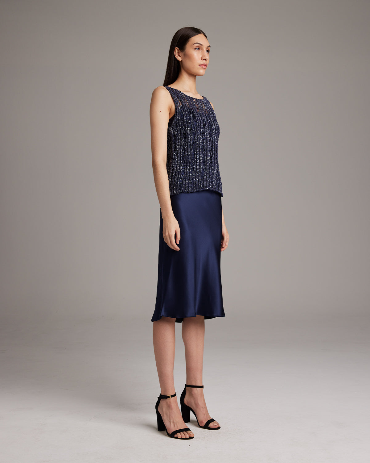 Model wearing a navy Lace Knit Tank with a satin skirt