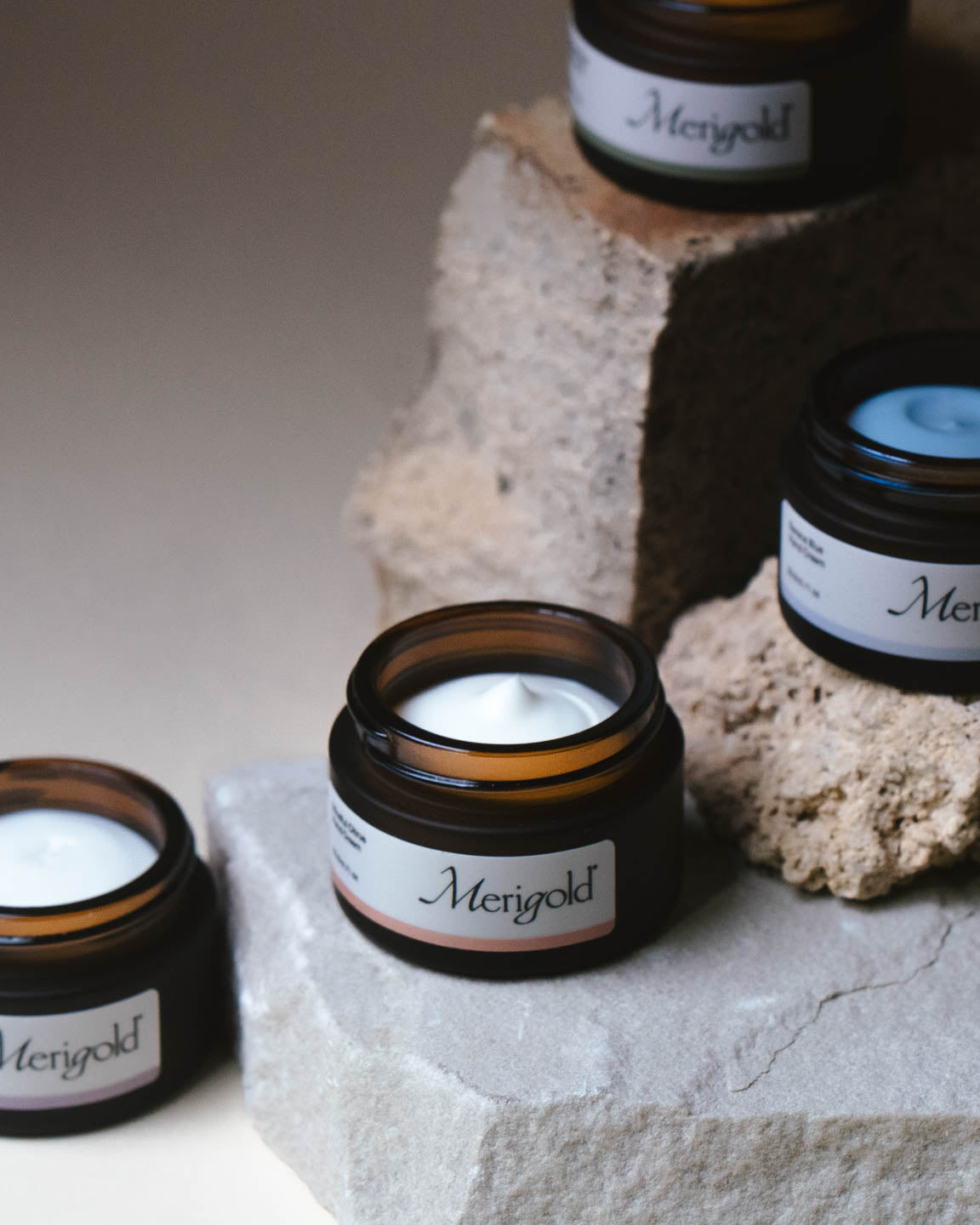 Close-up of Merigold mini hand cream collection on stone featuring Serene Blue, Mindful Citrus, Woodland Zen, and Lavender Eucalyptus.