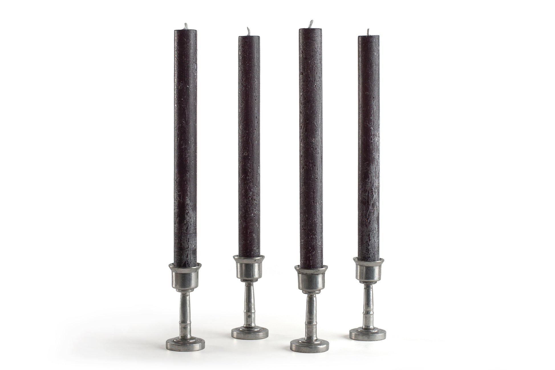 Four black candles with silver candle holders on a white background