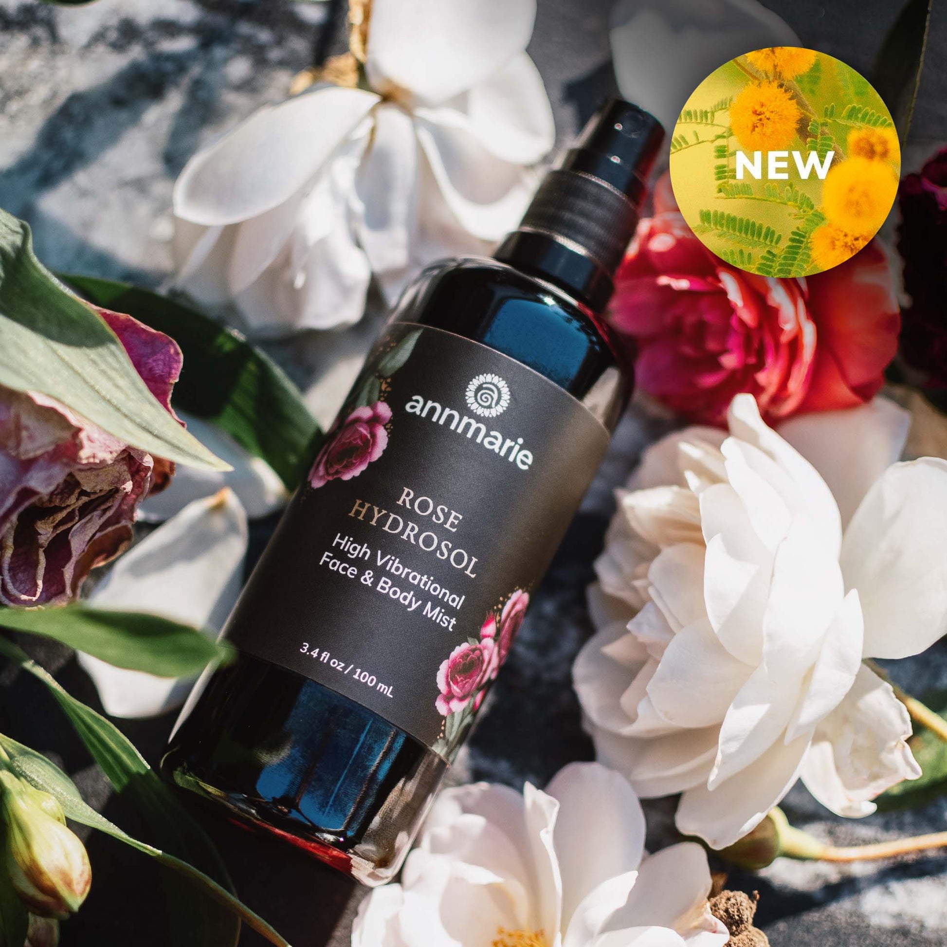 Annmarie Rose Hydrosol bottle surrounded by flowers with a 'NEW' label.
