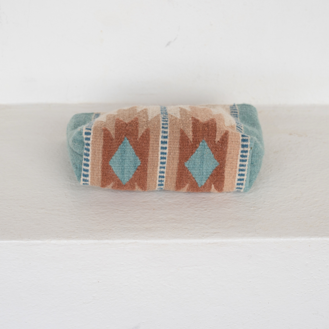 Handwoven pouch with abstract Zapotec lightning design in rose and blue tones, featuring internal pocket; ideal for use as a makeup bag, wallet, or tote organizer.
