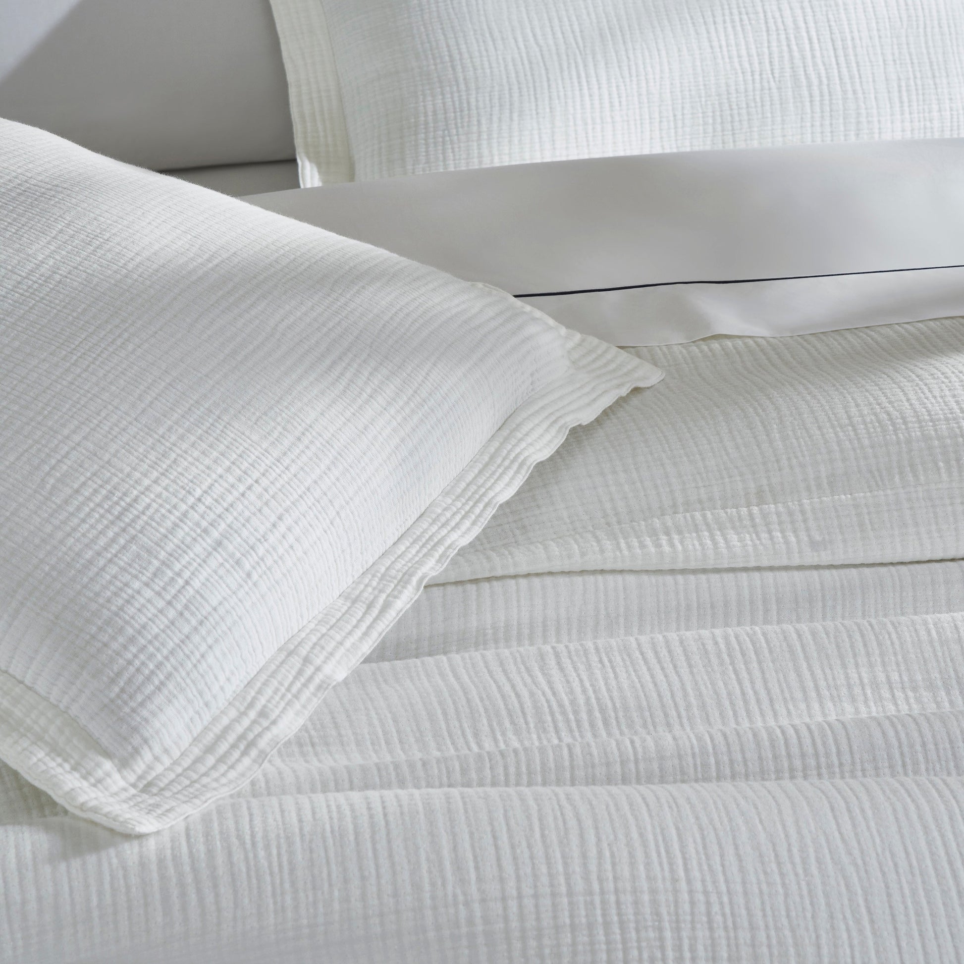 DT-048-10692_6|Close-up of soft white textured cotton gauze duvet cover fabric with a matching pillow sham. Comforting luxury bedding.
