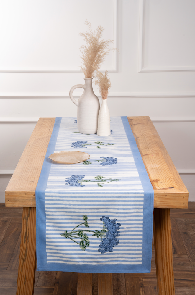 Blue hydrangea embroidered tablerunner with white stripes on wooden table