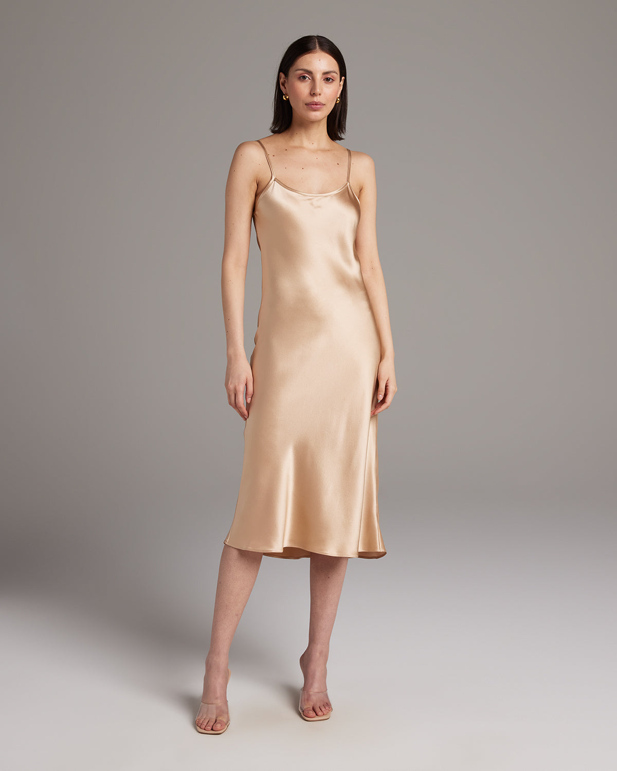 Model wearing a blush satin Midi Slip Dress with spaghetti straps
