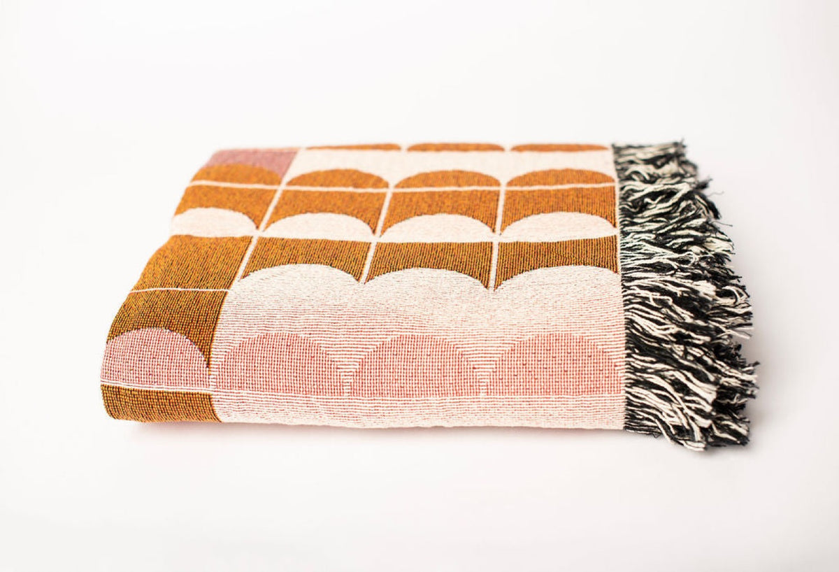 Close-up of Quinn Blush pink, cream, and ochre geometric woven cotton throw with fringe