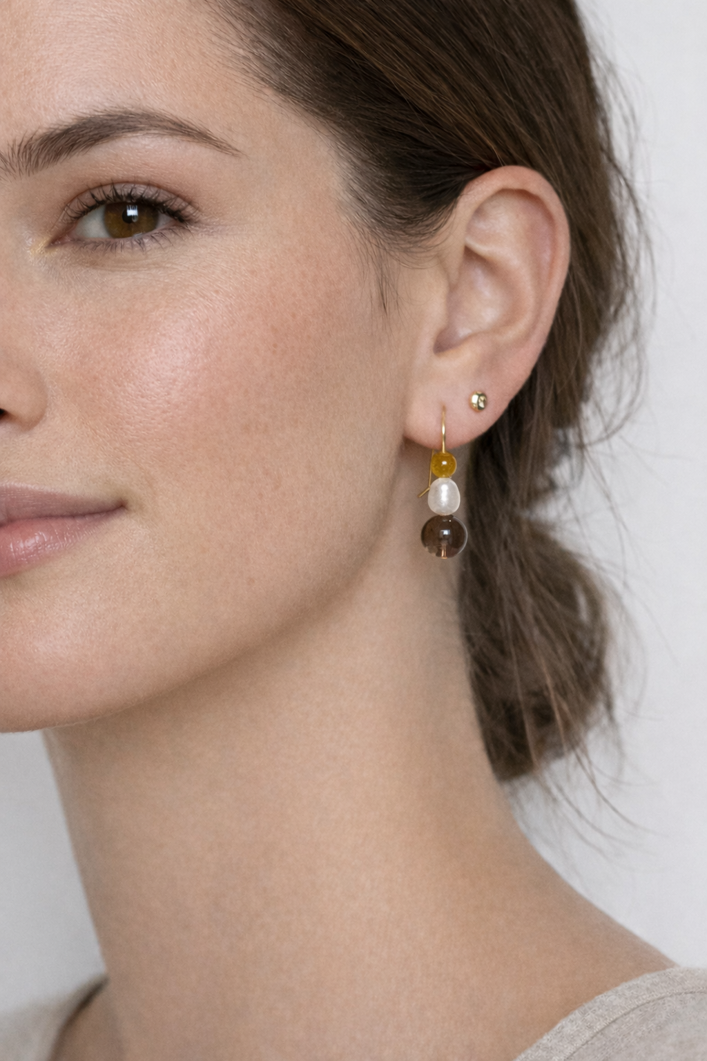 Close-up of a woman wearing earrings with a neutral background