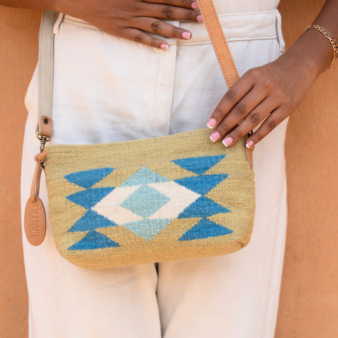 Closeup of handwoven convertible clutch with Zapotec butterfly design in bright spring colors; can be used as a pouch, wristlet, or crossbody with included leather straps and internal pocket