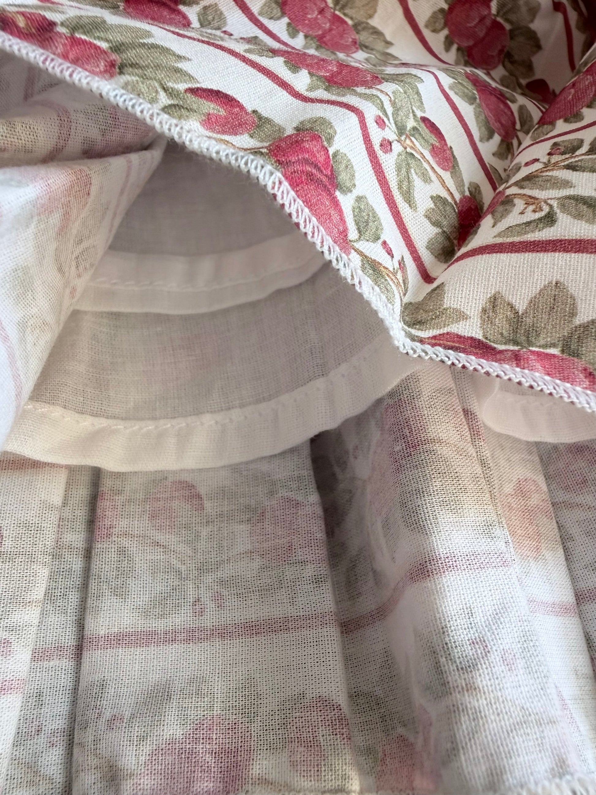 Close-up of floral fabric with red and green patterns on a beige background