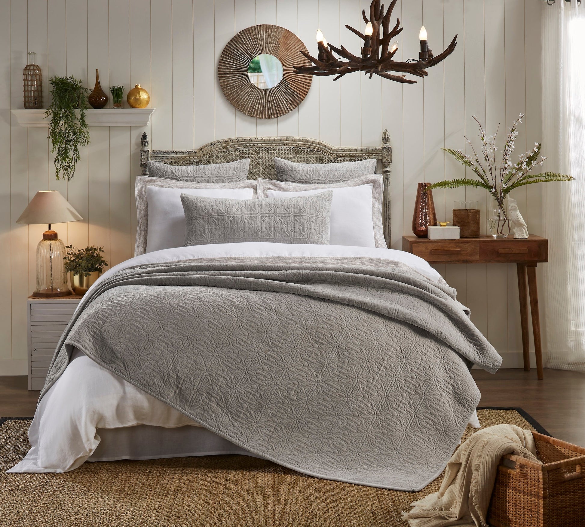 QT-331-9496-LOT1_1|Cozy light grey quilt featuring a sophisticated geometric quilted pattern, draped on a bed in a rustic-chic room.