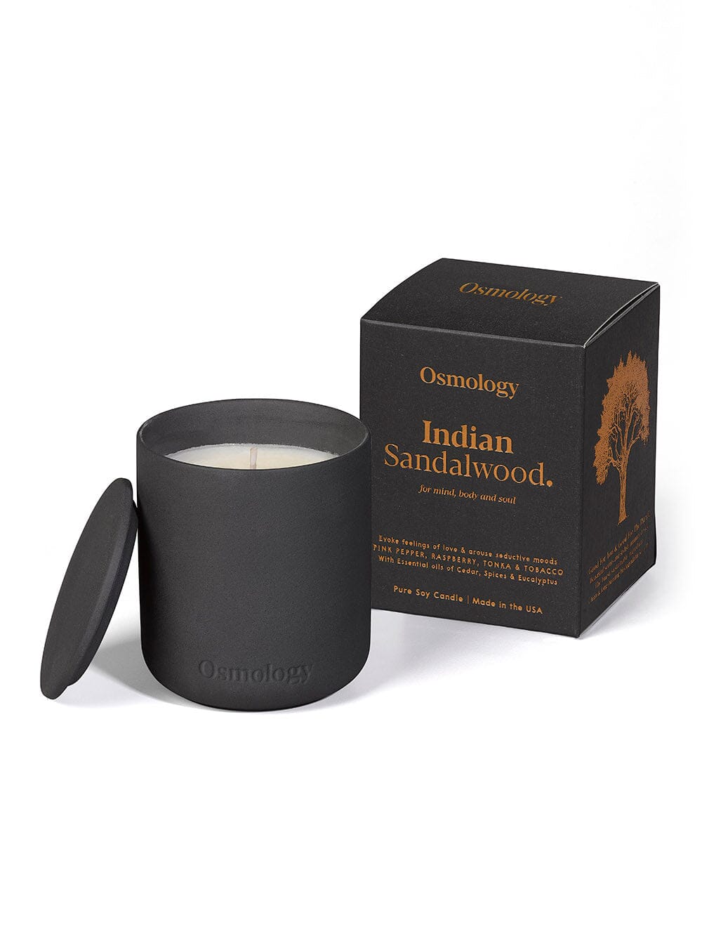 Osmology black ceramic indian sandalwood scented candle displayed next to decorative product packaging