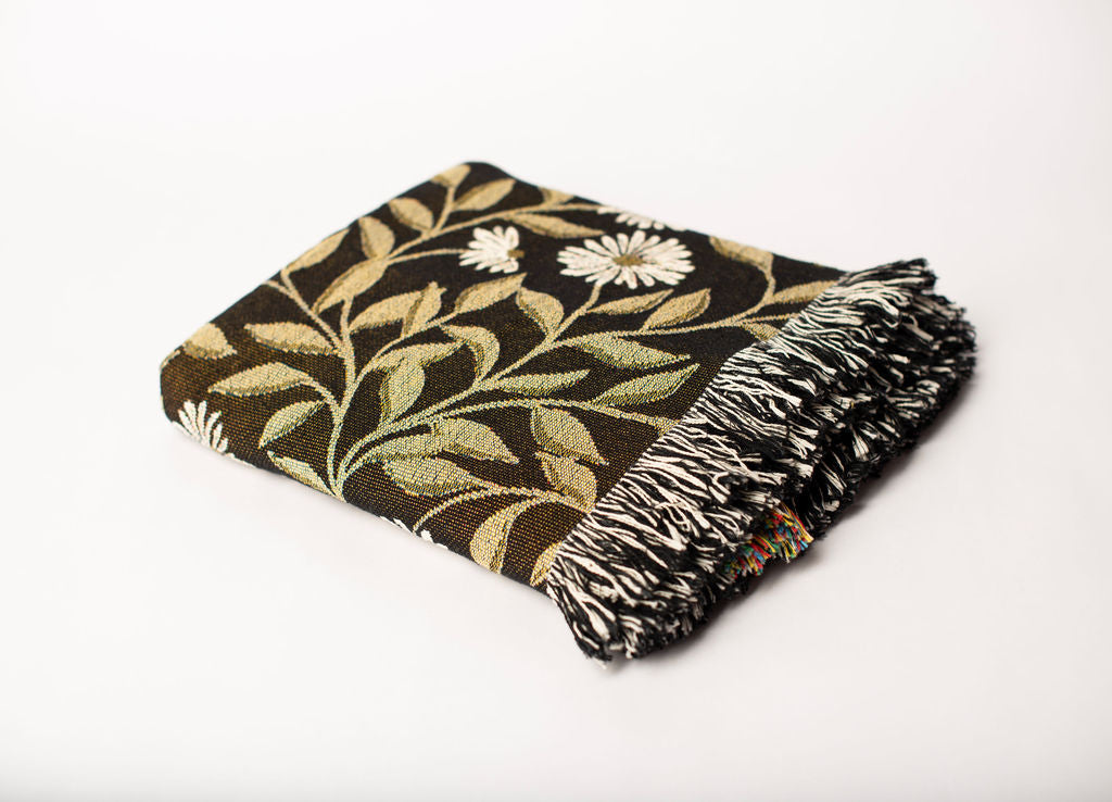 Folded May Bramble floral woven cotton throw blanket shown from the side