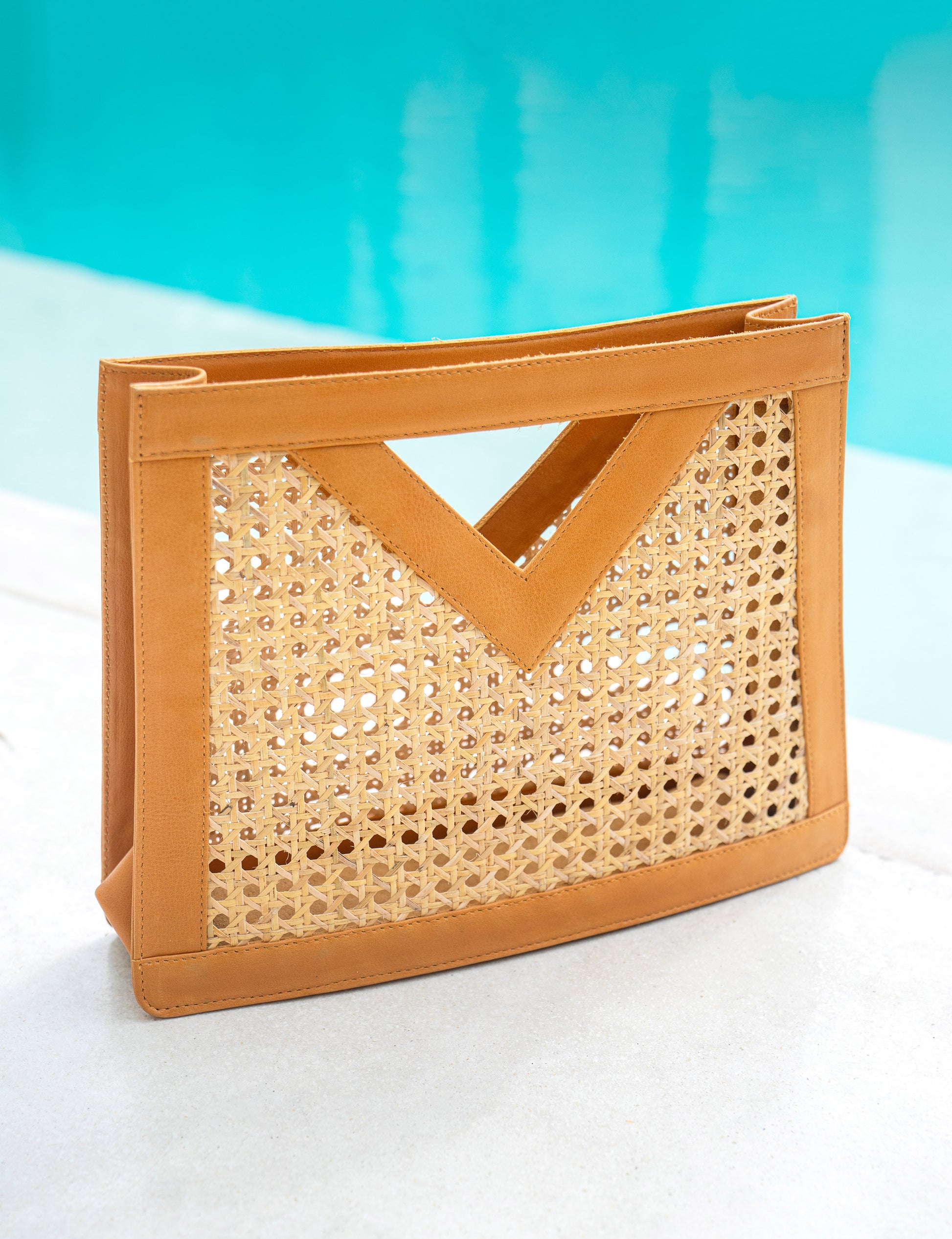 Tan Leather Trim and Rattan Cane Open Weave Top Handle Tote Handbag by the poolside