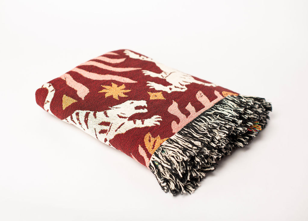 Folded Leona Solstice tiger-patterned woven cotton throw blanket shown from the side