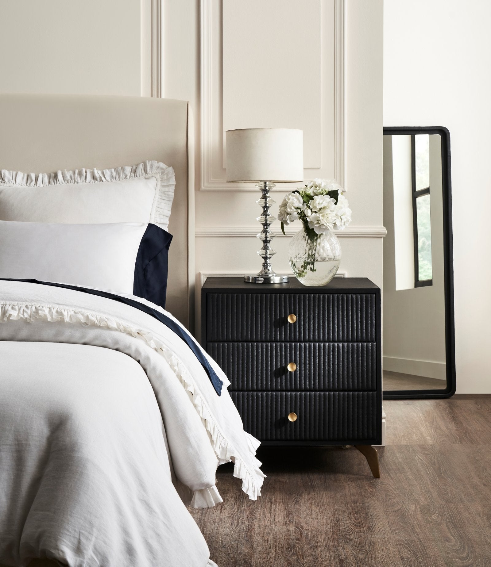 FN-5202-262028_2|Elegant black leather 3-drawer nightstand with vertical channel tufting and gold legs, complementing modern bedroom decor beautifully.
