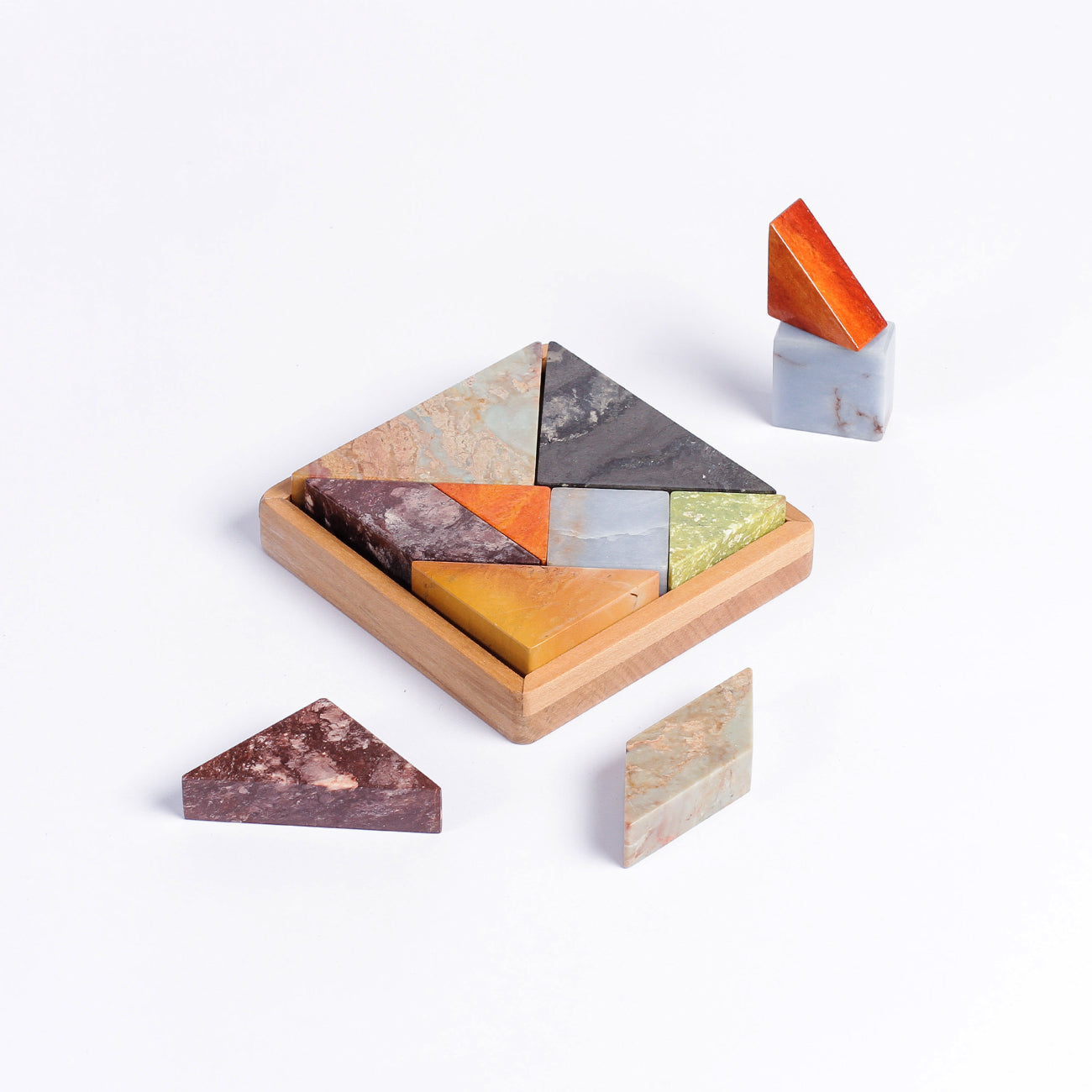 Multi-stone Tangram gemstone puzzle displaying intricate natural tones on a white background.