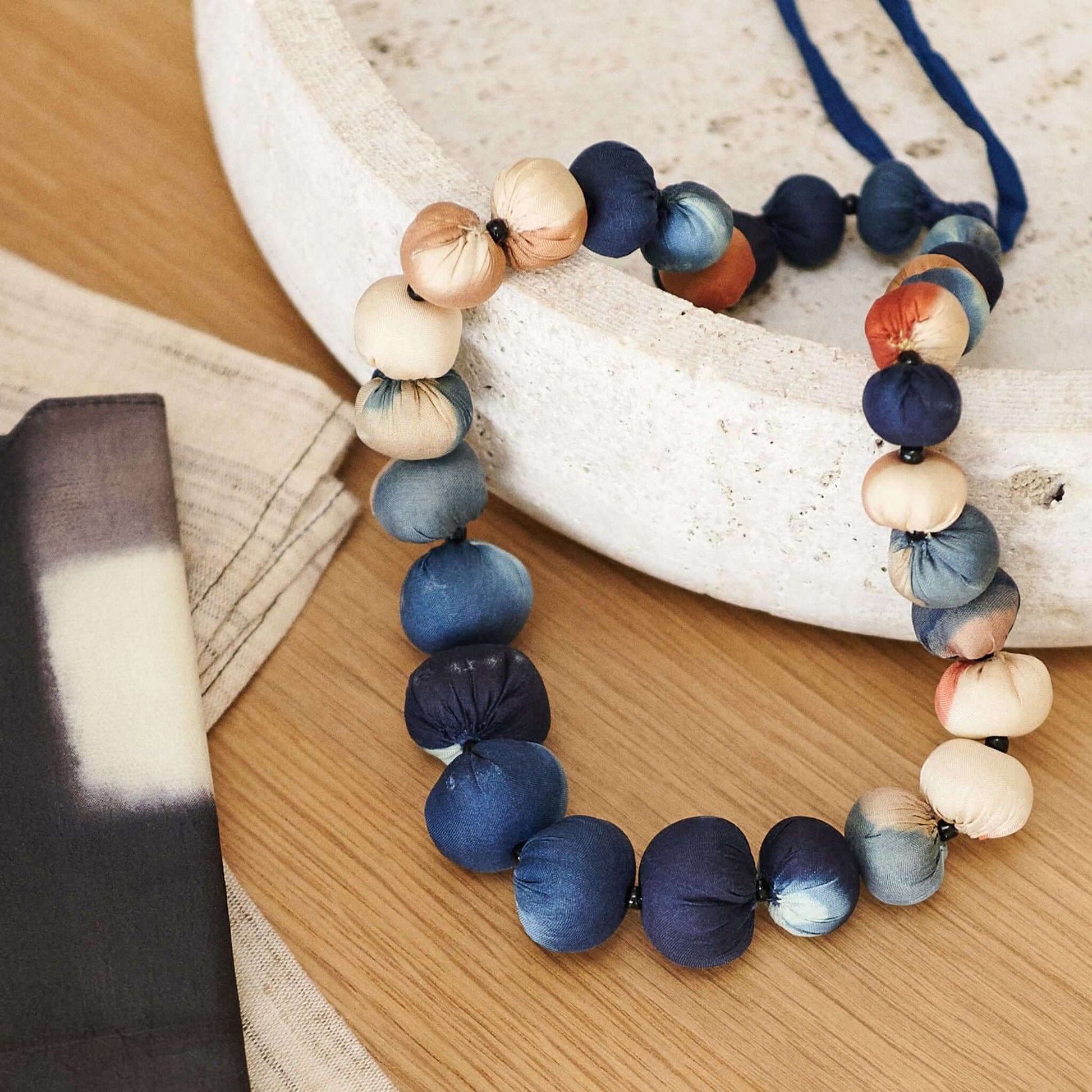 Mihika silk beaded necklace modern artisanal with handcrafted silk beads in shades of blue, cream, and orange.
