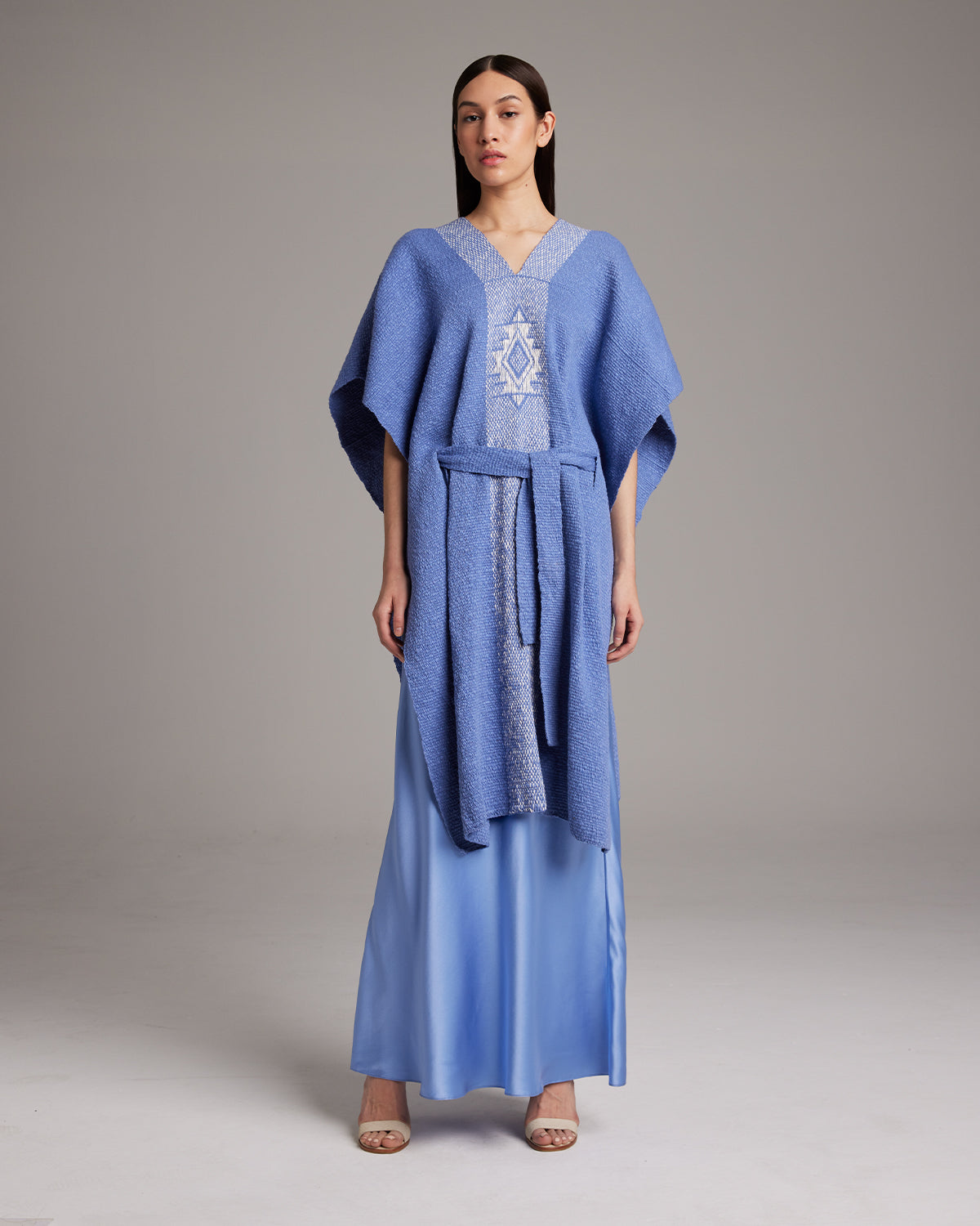 Model wearing a blue Estrella Kaftan with a textured design and belt
