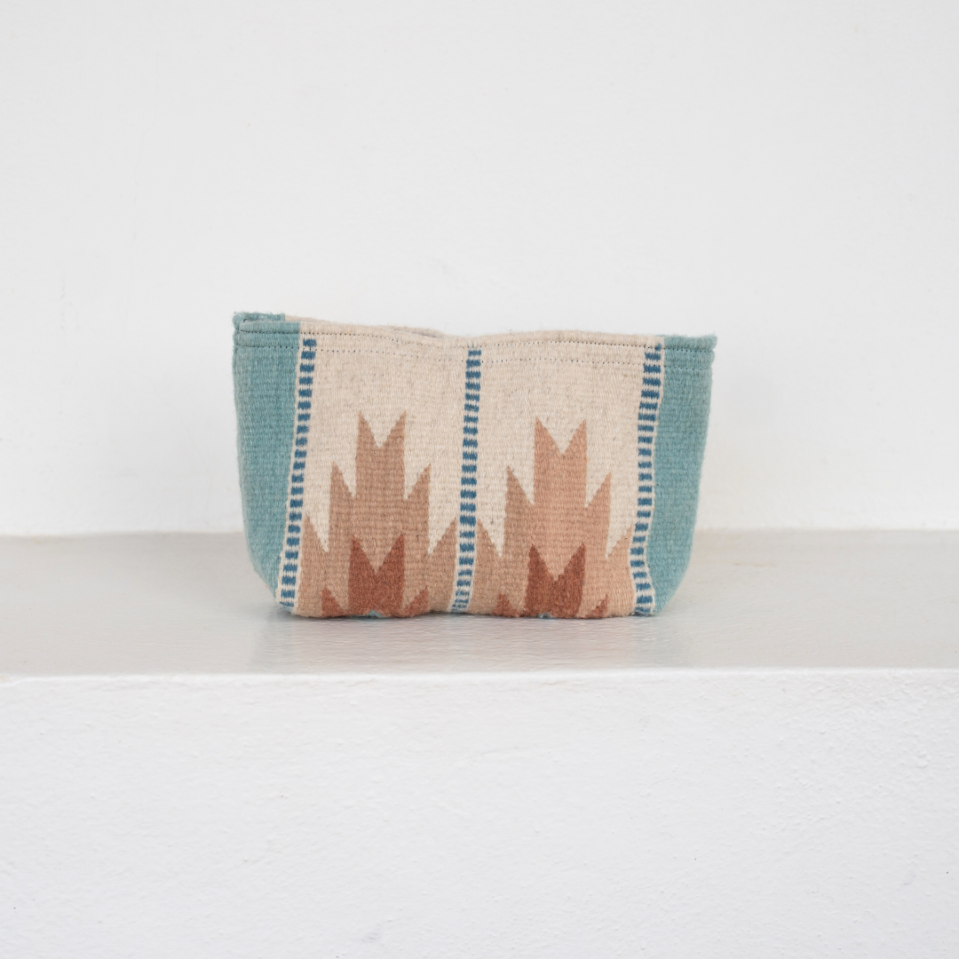 Handwoven pouch with abstract Zapotec lightning design in rose and blue tones, featuring internal pocket; ideal for use as a makeup bag, wallet, or tote organizer.