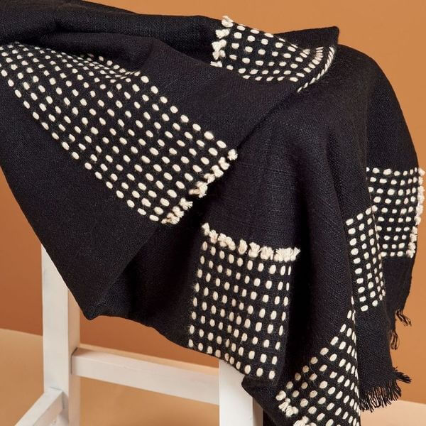 Walnut Black Yak With Hand Knotted Merino Stripes Handloom Throw displayed on a chair with patterned design.