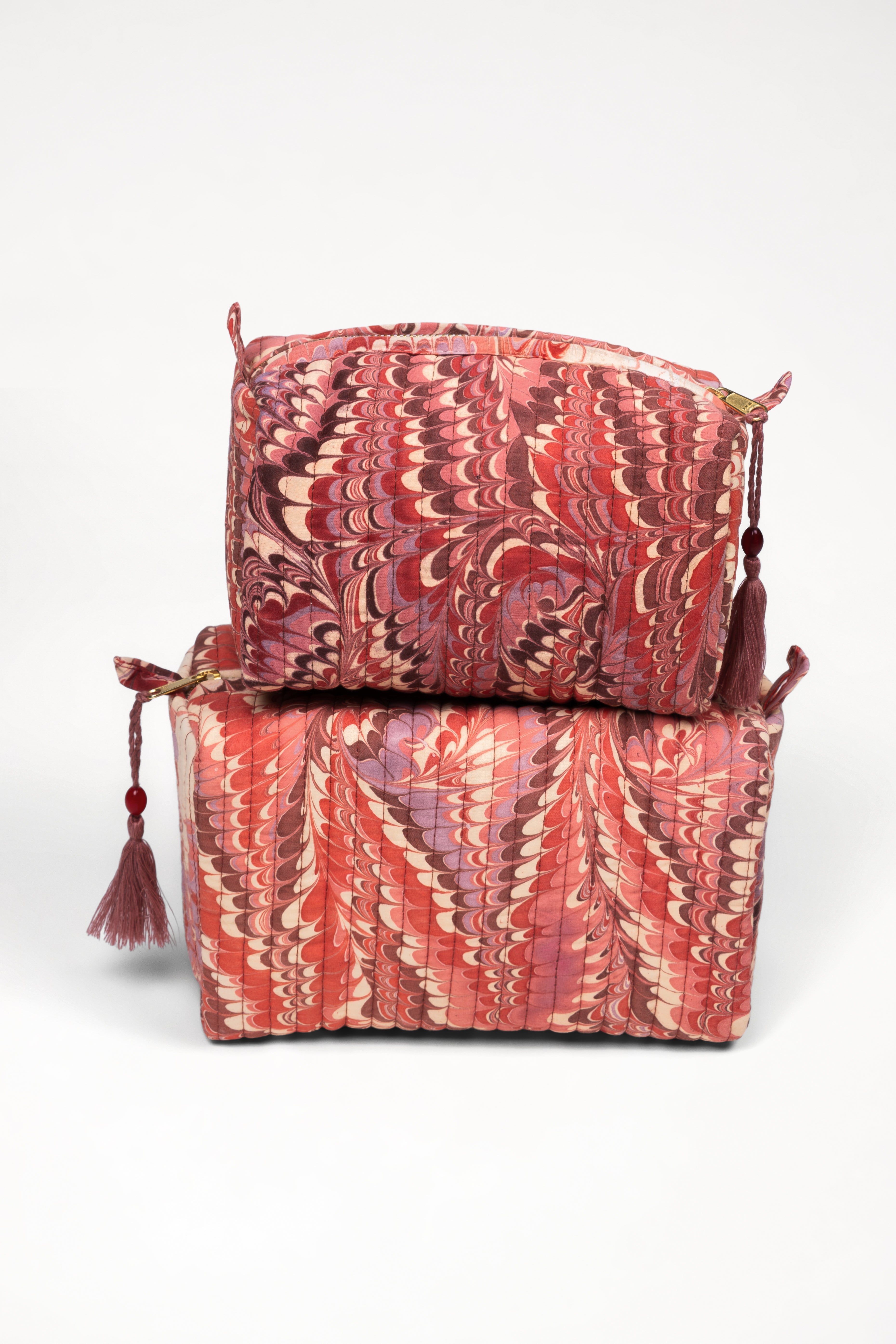 Stacked florentine pink hand-marbled quilted cosmetic bags with tassels