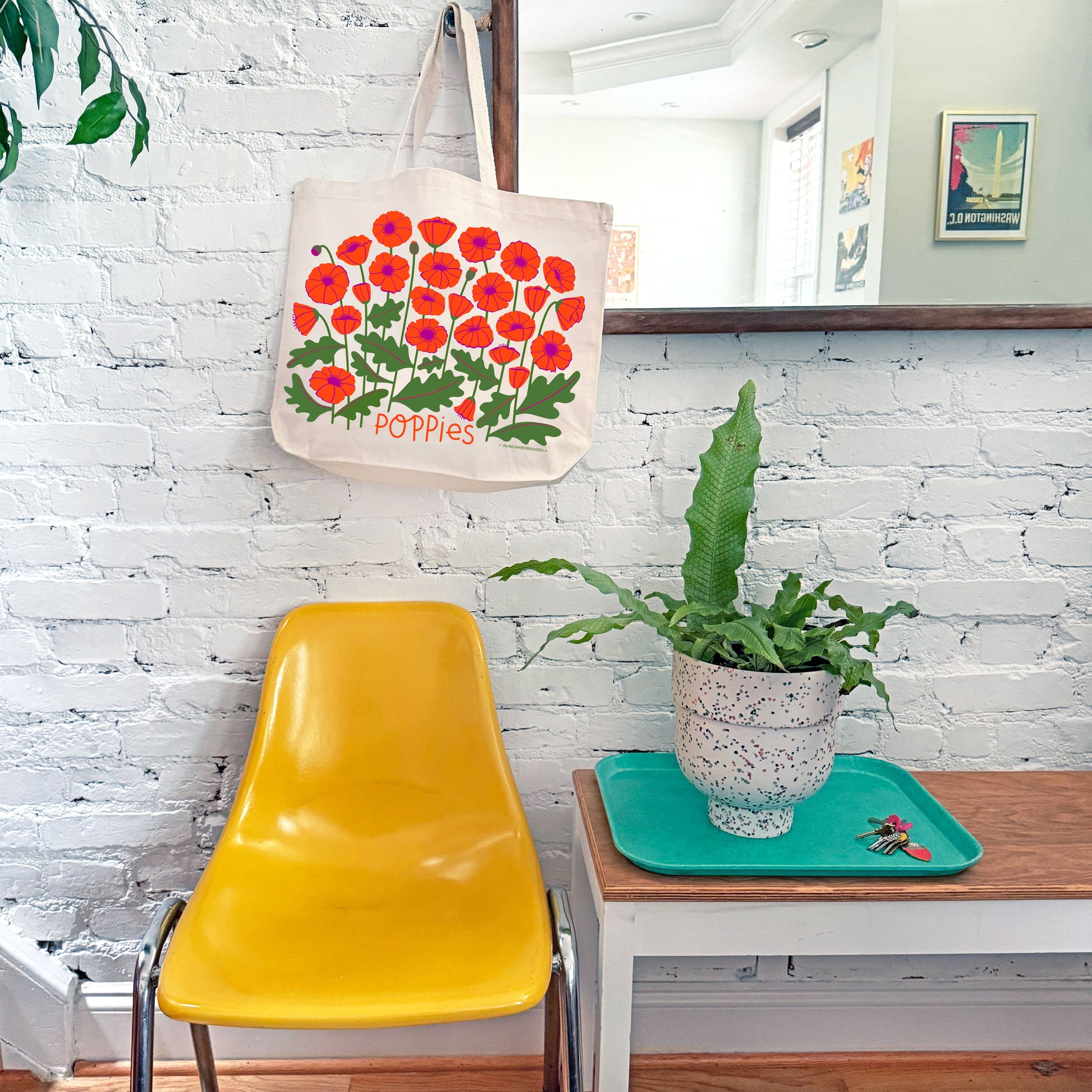 The Poppies tote bag hangs on a mirror hook.
