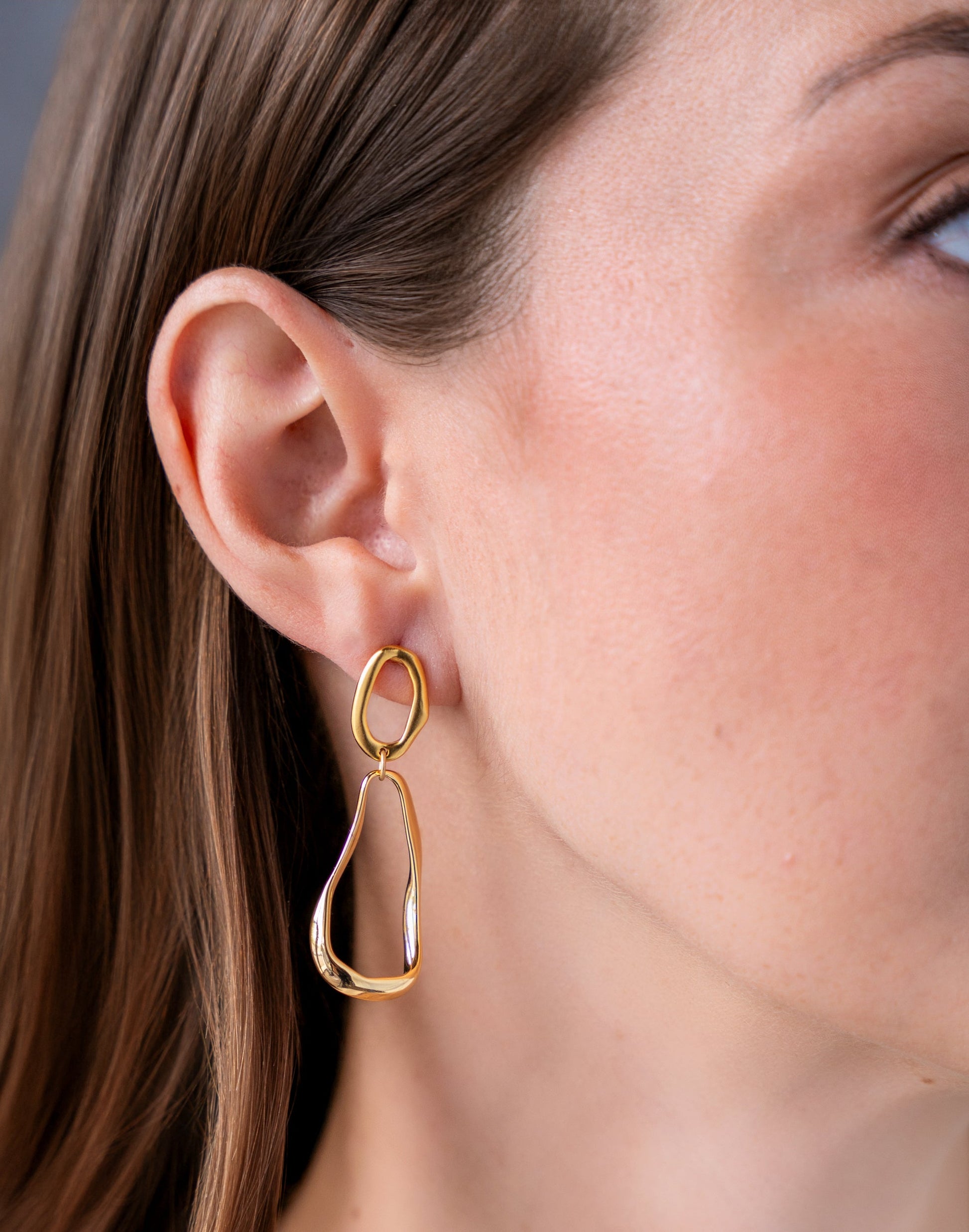 Gold organic shape drop earrings with abstract open sculptural design.