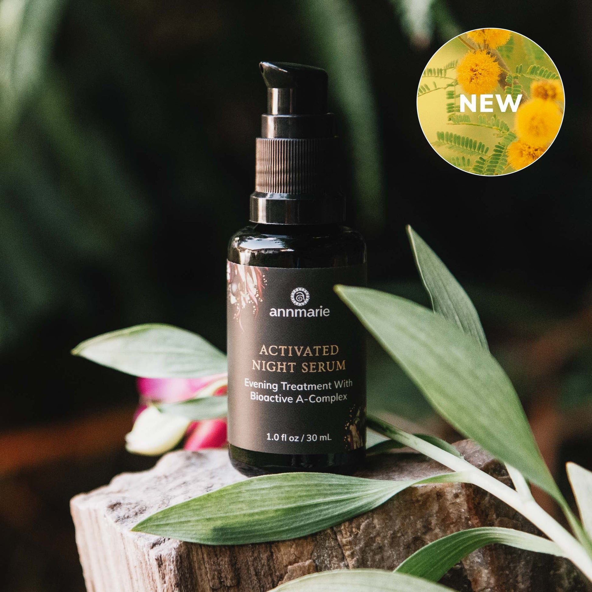 Activated Night Serum bottle on a wooden surface with green leaves and a 'NEW' label in the corner.
