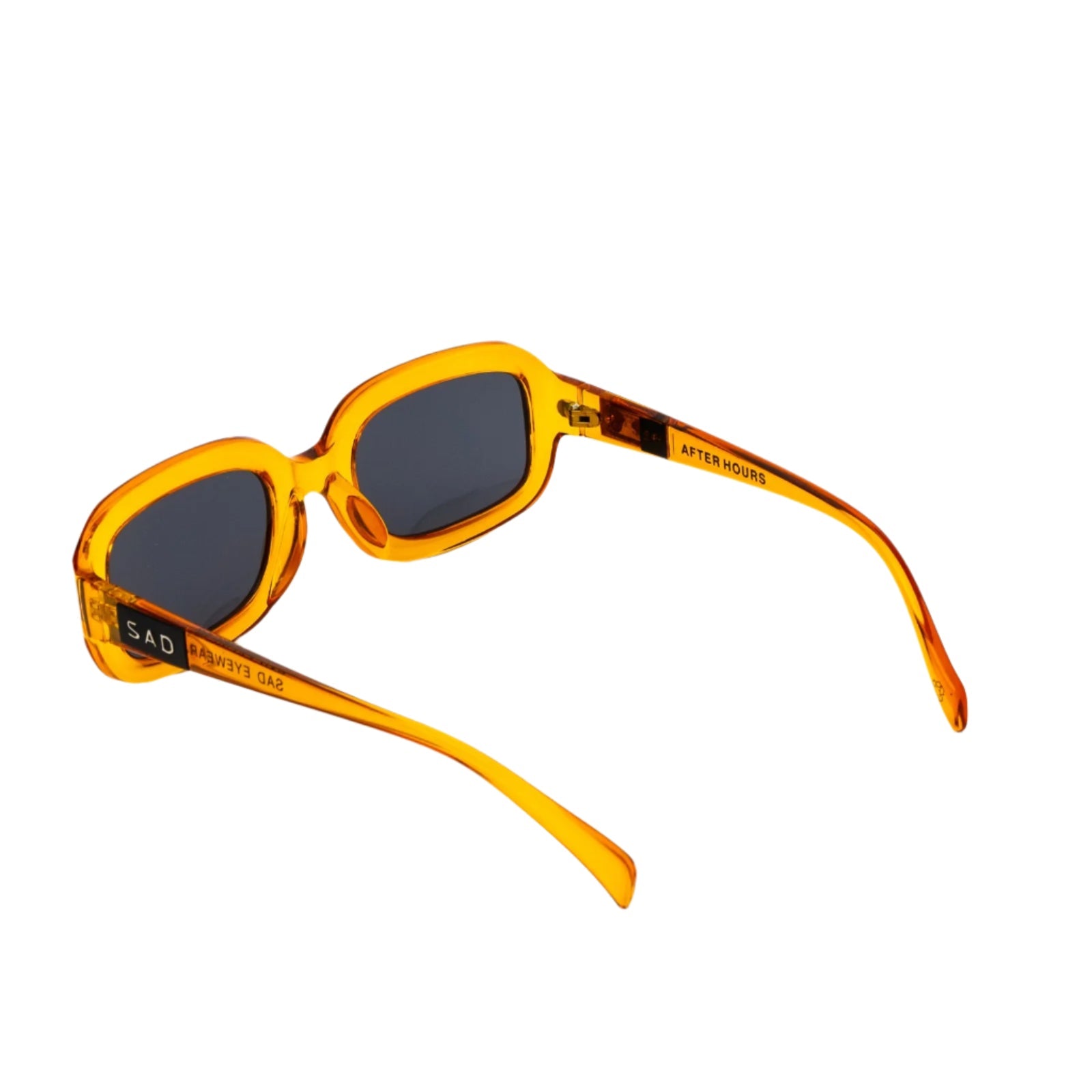 Sunglasses with amber frame and dark lenses on white background