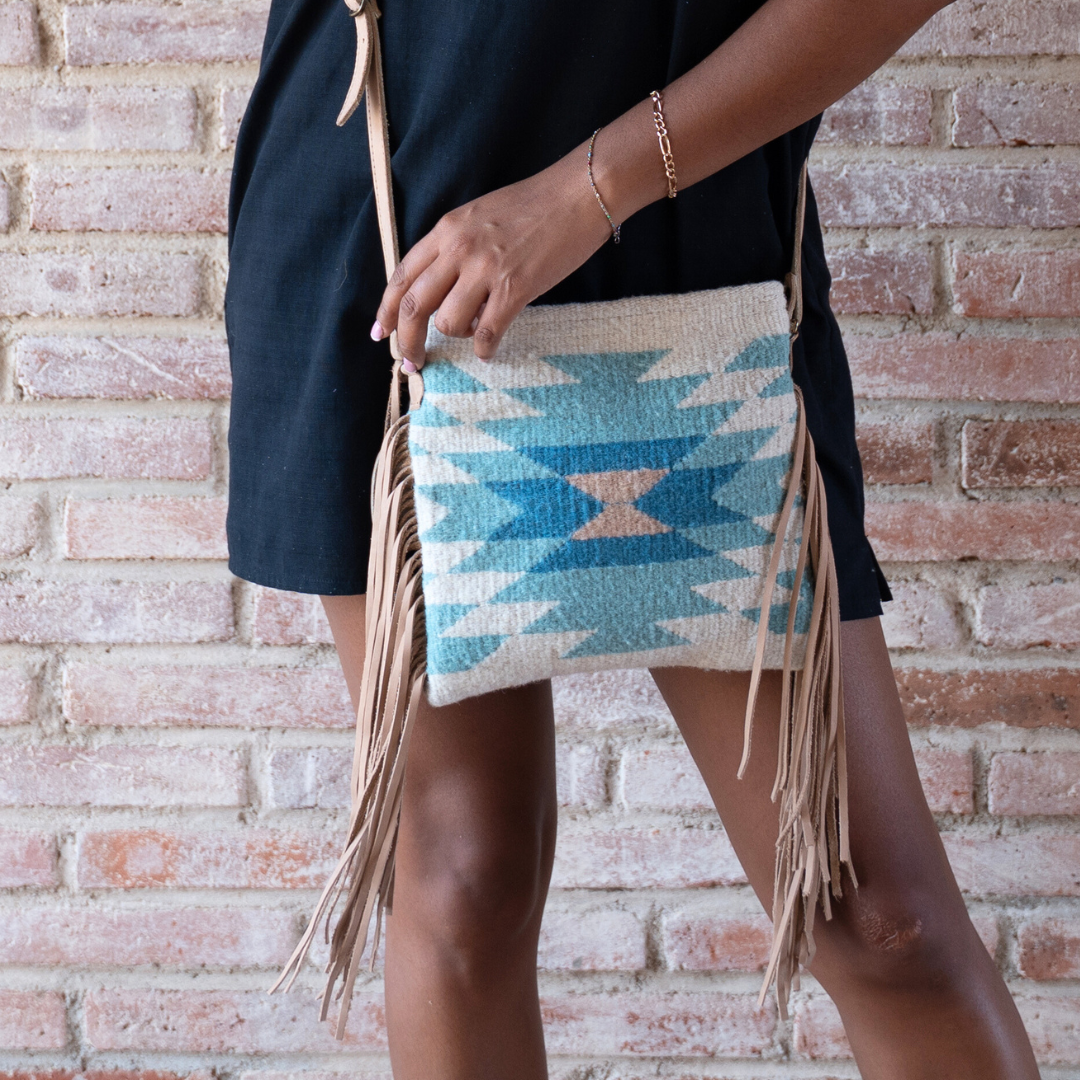 Interior view of handwoven fringe crossbody bag with abstract Zapotec diamond design in soft spring colors; features adjustable leather strap and two internal pockets