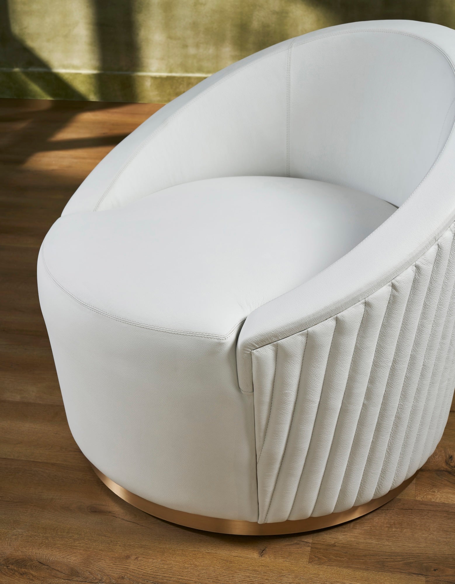 FN-5206-353529_6|Close-up of luxurious white leather swivel armchair, highlighting plush seating and elegant vertical ribbed design, premium furniture.