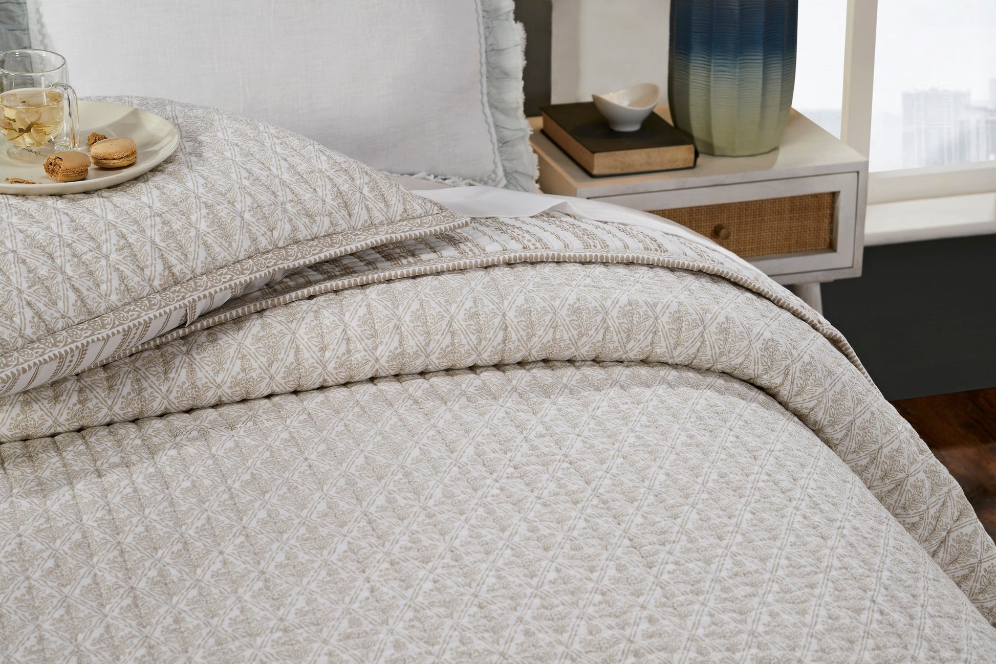 QT-348-9496_4|Close-up of a luxurious cream quilt with intricate gold geometric patterns, soft texture, draped over a bed. Cozy bedroom decor.