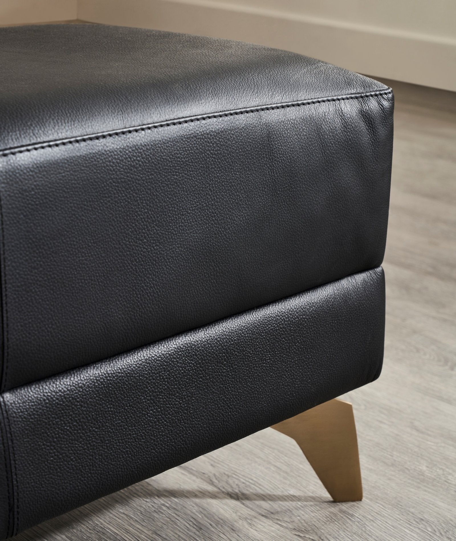 FN-5200-601618_3|Close-up of premium black leather bench, highlighting textured upholstery and elegant gold finish on tapered furniture legs.