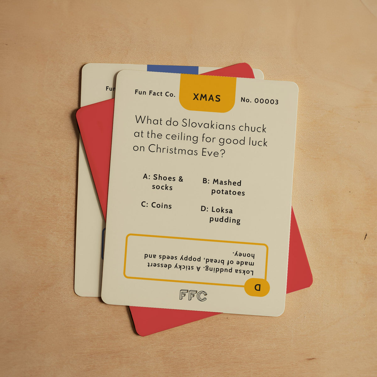 Card with Christmas-themed trivia question on a wooden surface