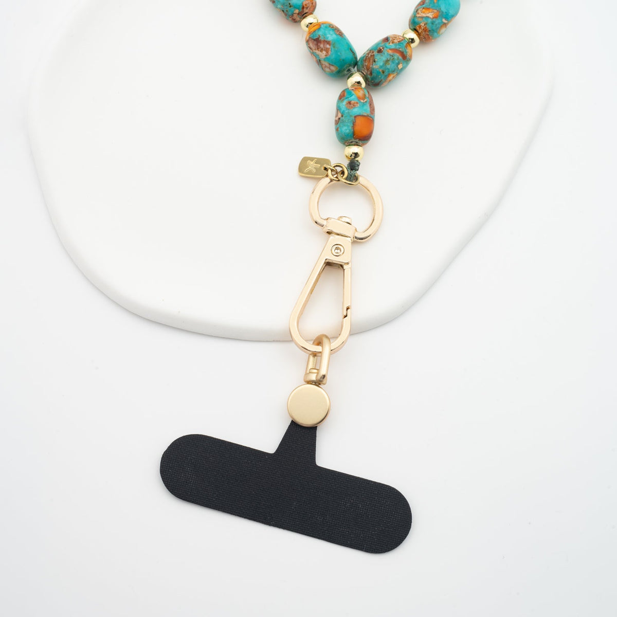 Sierra Bloom turquoise beaded wrist strap with gold clasp and black phone adapter
