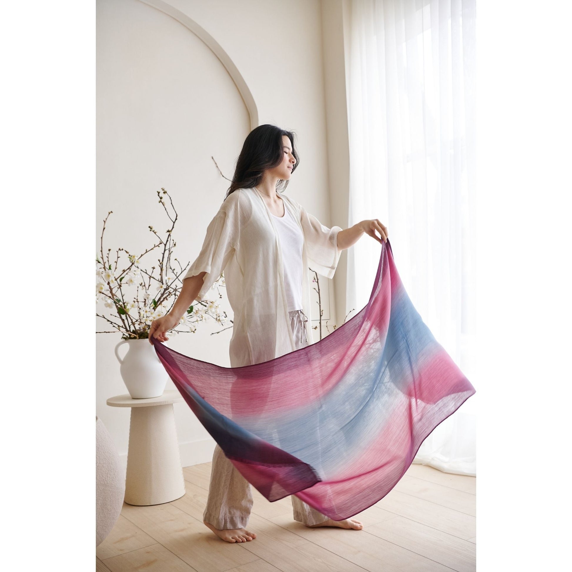 Model showcasing the Iris Haze Blue Pink Cashmere Merino Handloom Scarf indoors with natural light.