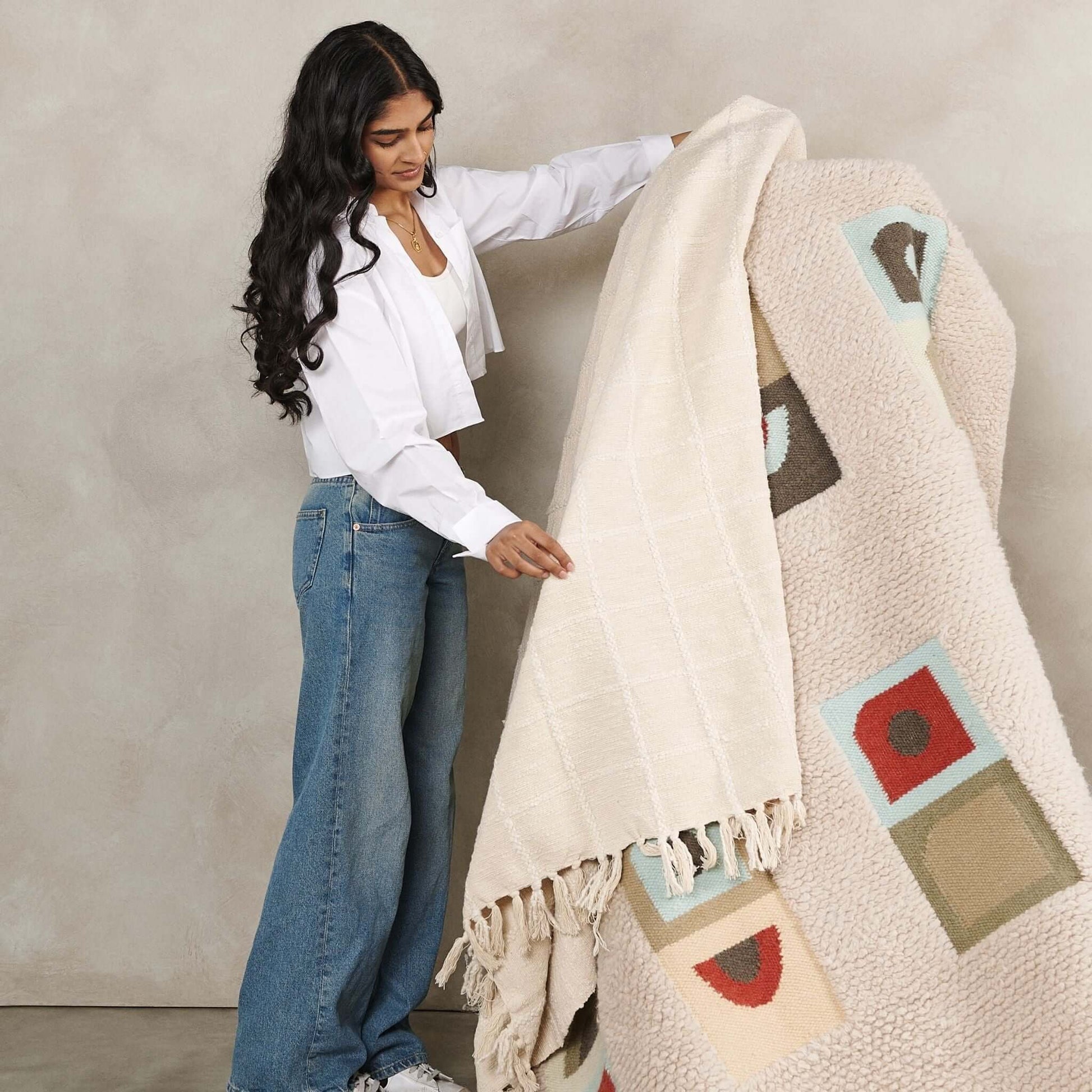 Sea Shell White Textured Checks Handloom Throw being showcased by a model, highlighting its unique texture and design.
