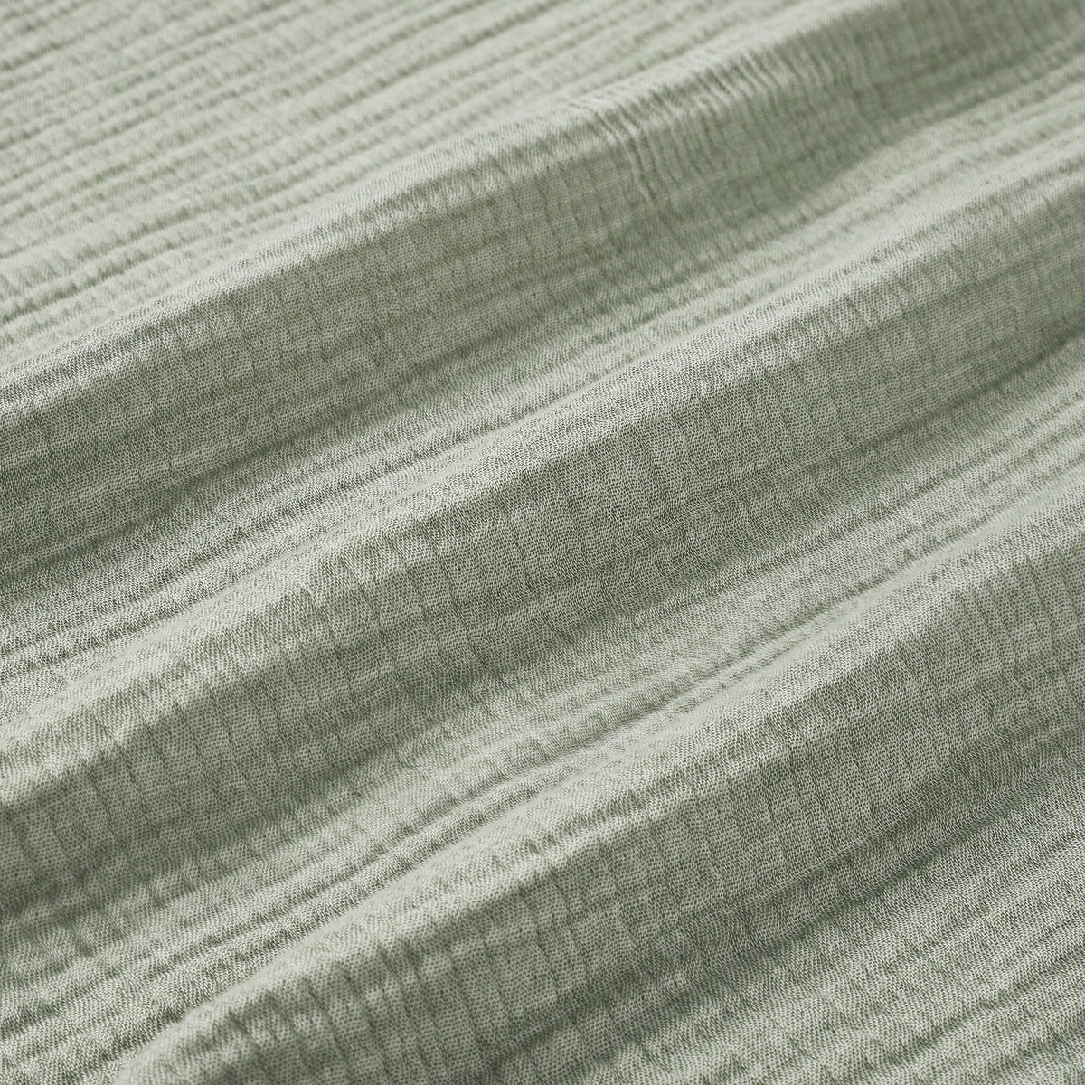 BL-864-9496_9|Detailed close-up of a soft sage green textured blanket, highlighting its cozy crinkled fabric and natural fibers.