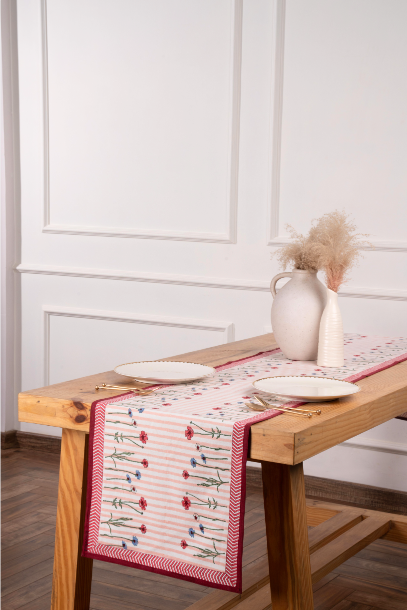 Inner Child Wildflower Tablerunner with pink stripes, red border, floral designs on wooden table