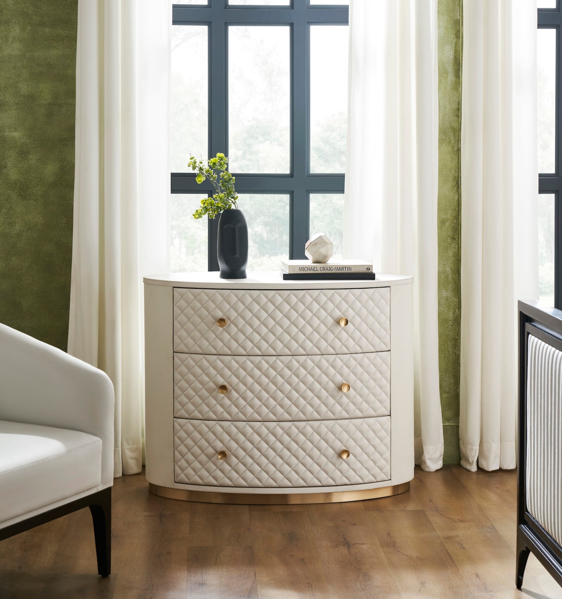 FN-5218-482036_6|Elegant white leather oval chest of drawers, featuring a chic quilted design, radiant gold hardware, and a sleek gold base.