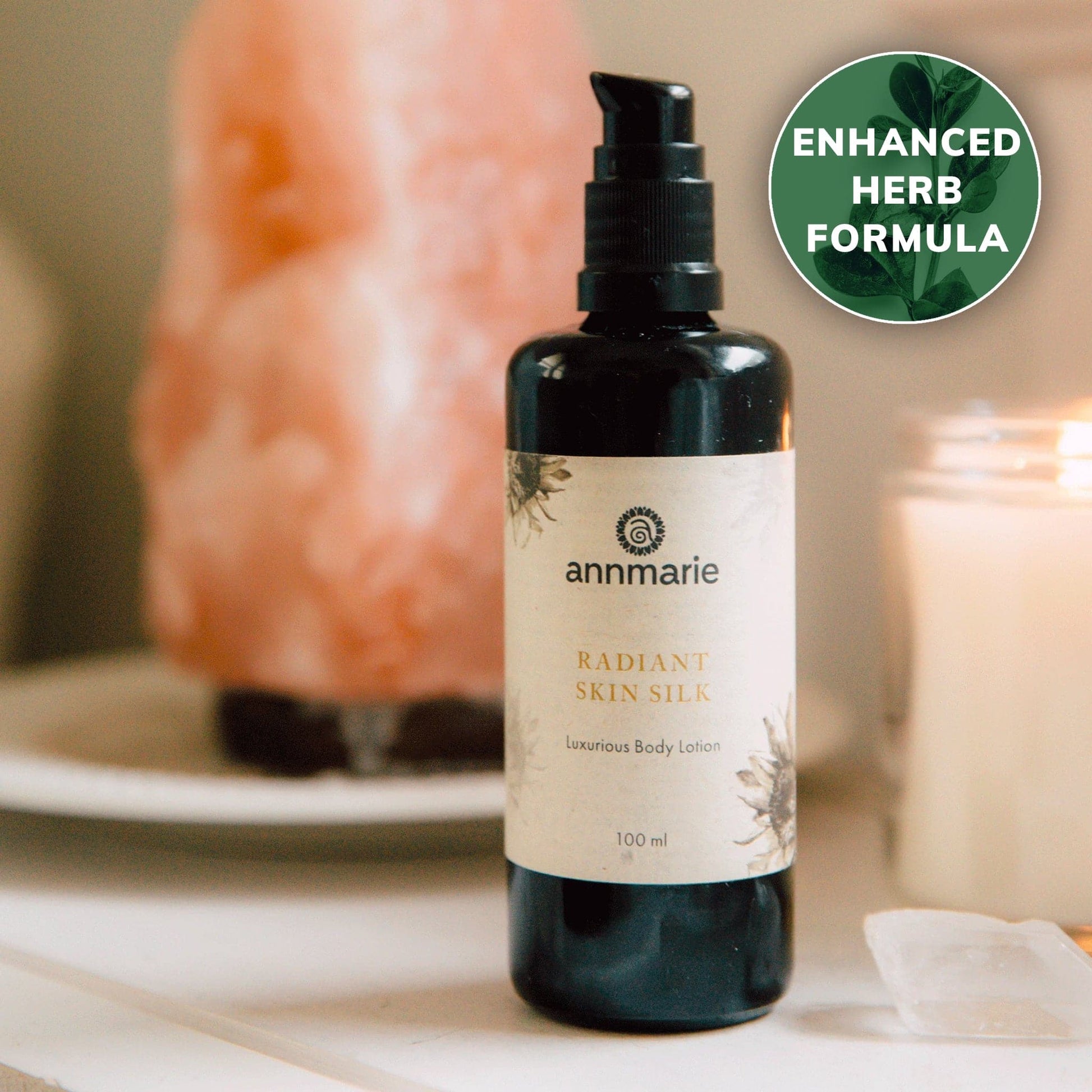 Bottle of Annmarie Radiant Skin Silk body lotion with a blurred background