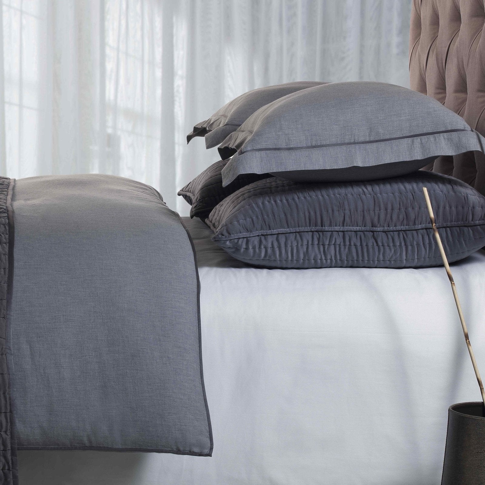 DT-011-X_2|Close-up of a sophisticated grey comforter set featuring textured bedding and layered charcoal pillows for elegance.