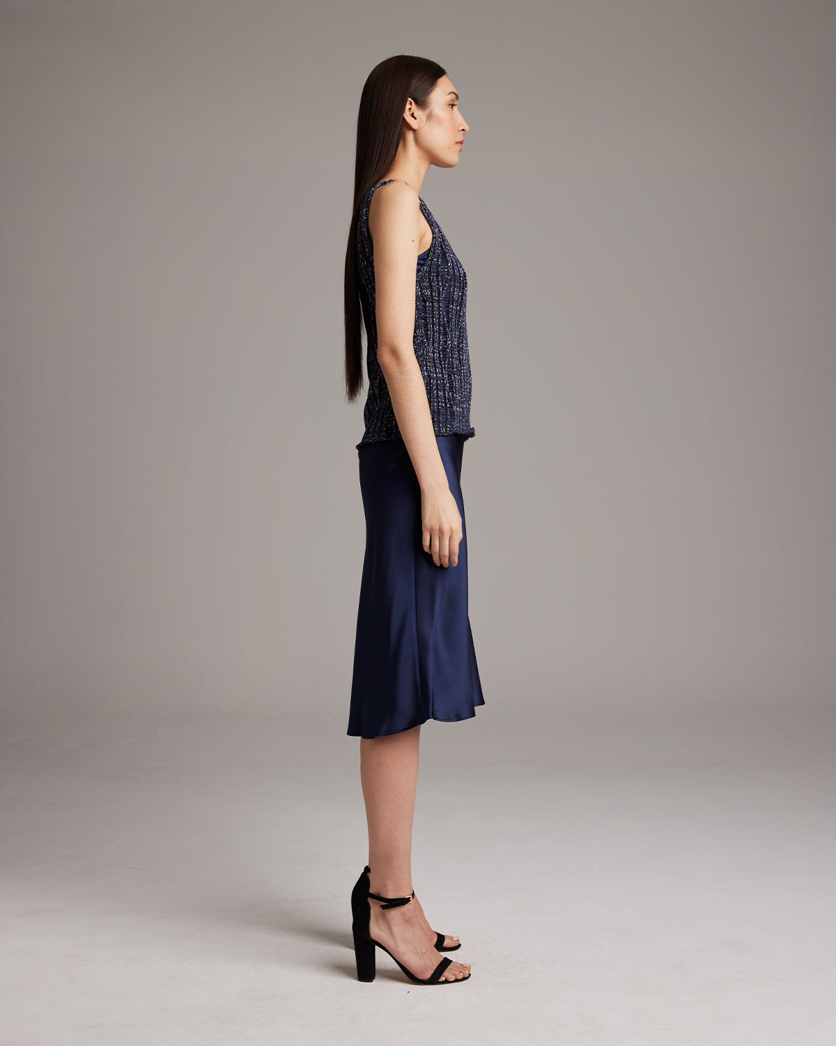 Model wearing a navy Lace Knit Tank with a skirt, side view