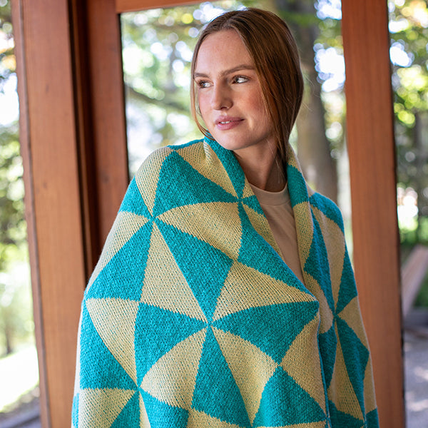 Woman wrapped in a aqua blue windmill patterned cotton throw in the  outdoors.