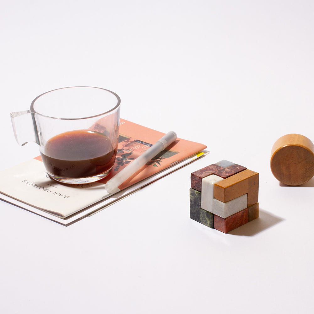 Low-angle perspective of the handcrafted stone Soma cube, emphasizing its architectural shape and sculptural presence.
