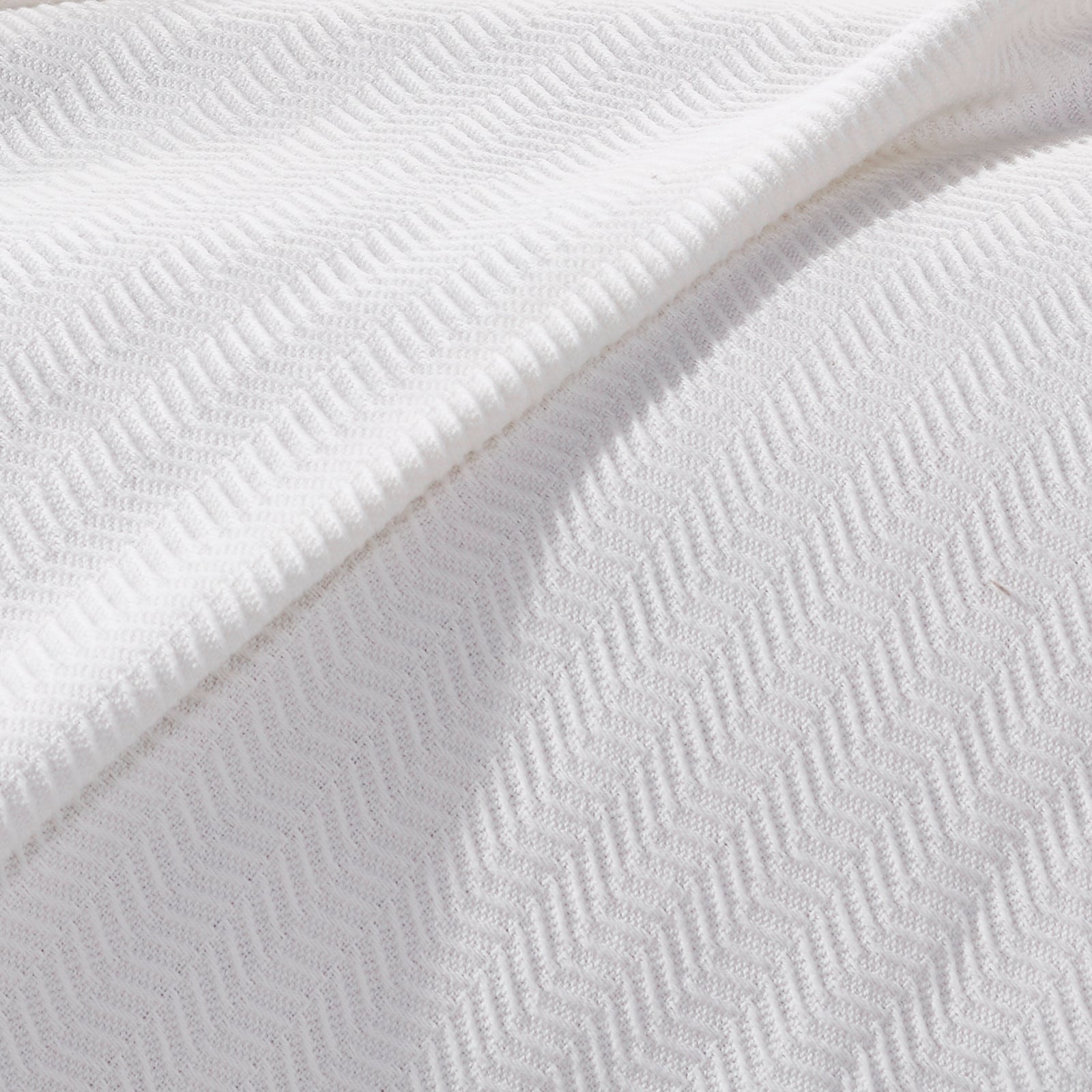 BL-854-9496_4|Detailed close-up of a luxurious white herringbone knit blanket, showcasing its soft texture and intricate pattern.