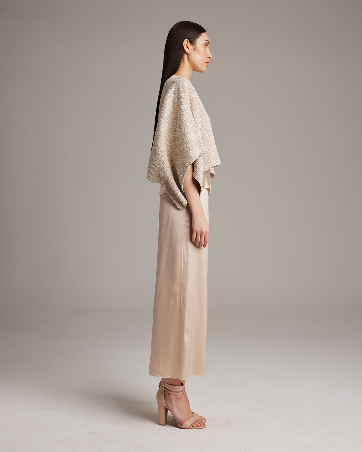 Model wearing a pearl crop top with a textured surface, side view