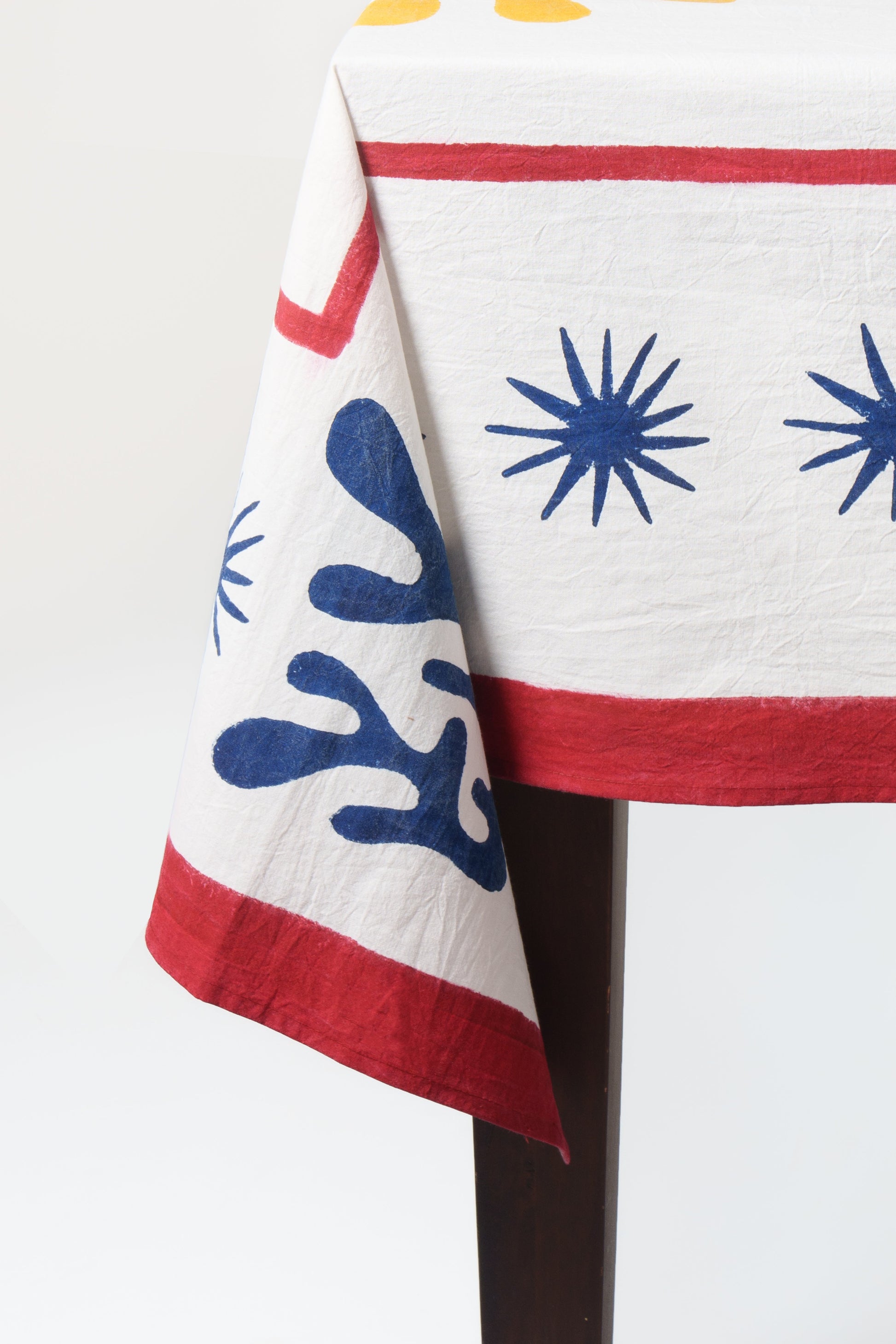 Celestial Matisse Blockprint tablecloth close-up showing blue starbursts and red border