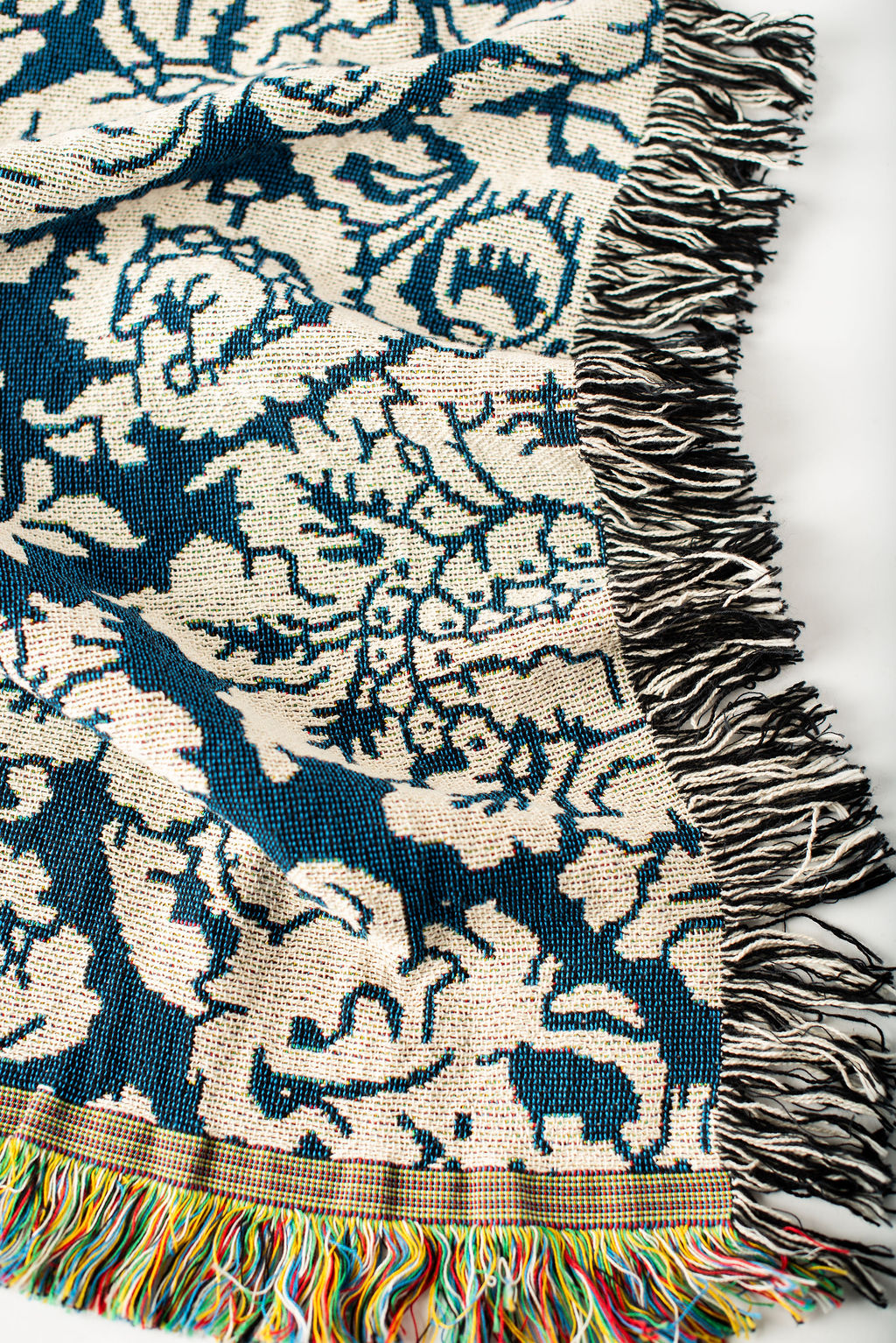 Close-up of Verona Cerulean blue and cream damask floral jacquard woven blanket with fringe