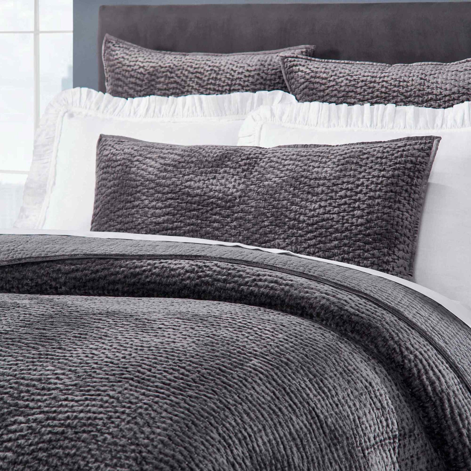 CL-184-9496-LOT1_3|Close-up of a charcoal grey textured waffle weave coverlet set with white ruffled shams, highlighting bedding detail.